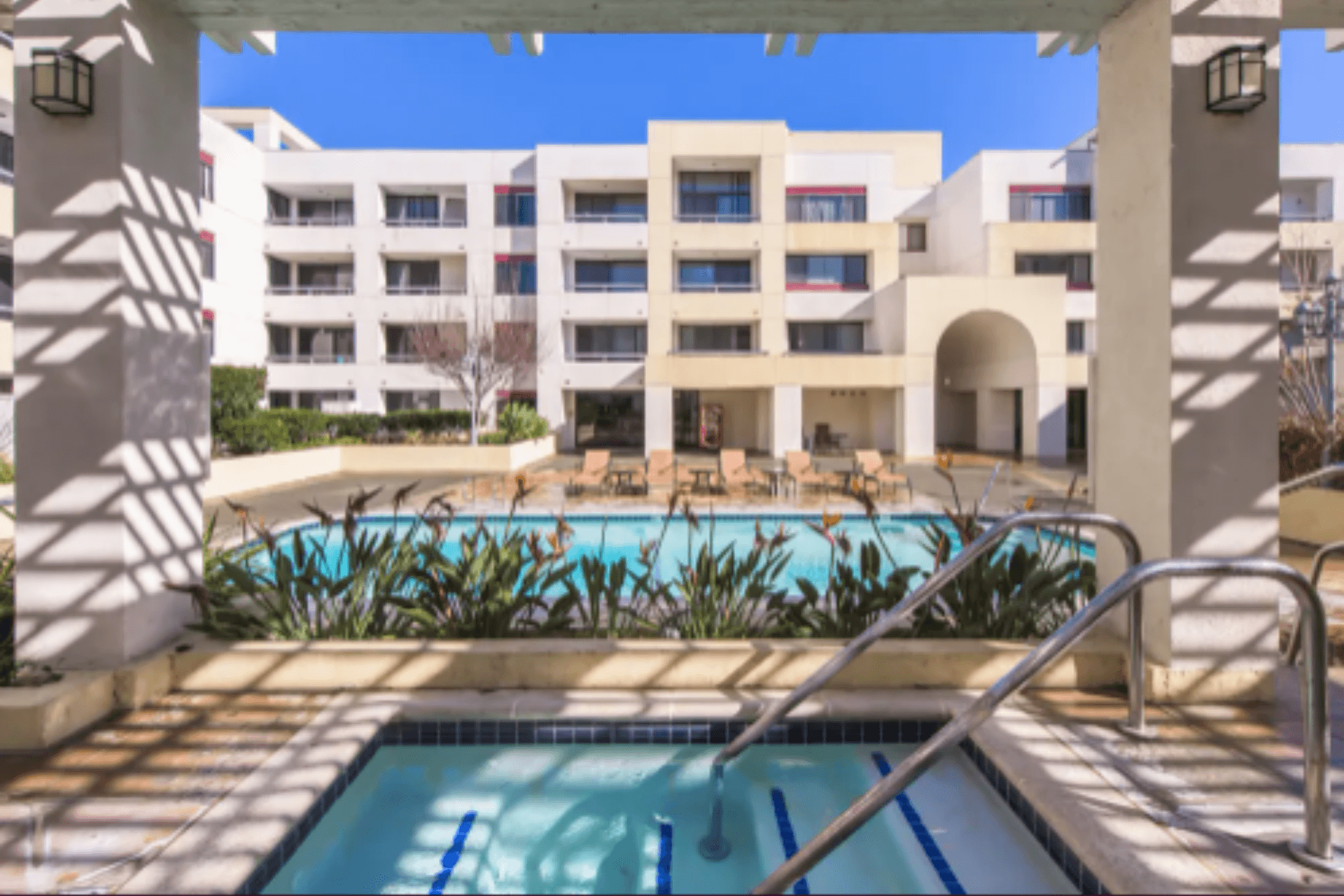 Apartment courtyard with outdoor swimming pool and white multi-story buildings